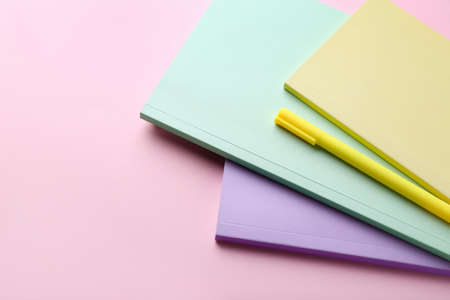 Notebooks and pen on pink backgroundの写真素材