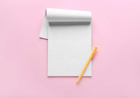 Notebook and pen on pink background