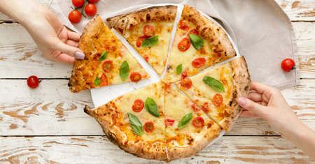 People taking slices of delicious pizza Margherita from table, top view