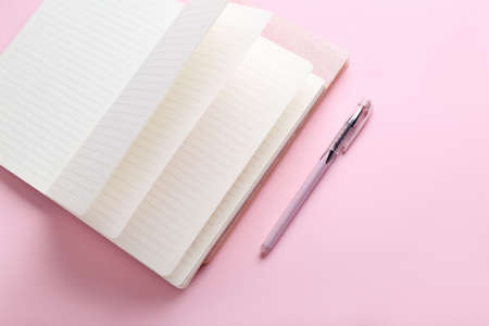 Notebook and pen on pink backgroundの写真素材