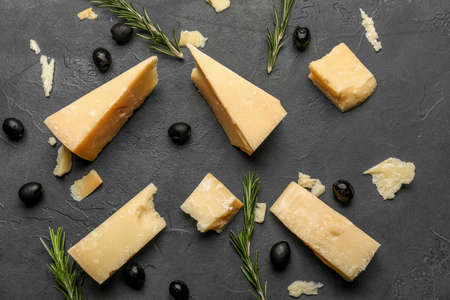 Composition with tasty Parmesan cheese, rosemary and olives on black backgroundの写真素材