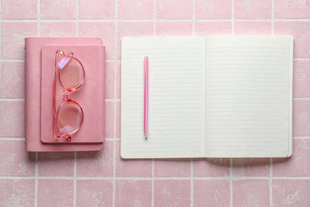 Notebooks and pen on pink backgroundの写真素材