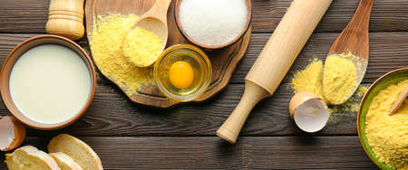 Corn flour with fresh products and kitchen utensils on wooden background