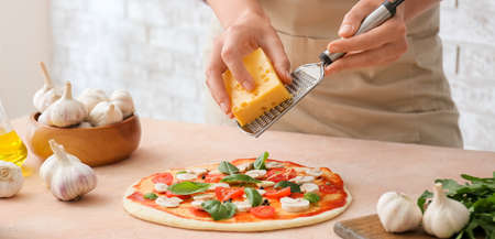 Woman cooking tasty pizza in kitchen, closeupの写真素材