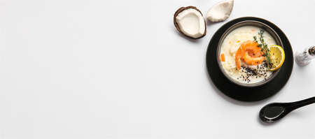 Bowl with tasty Thai rice soup on light background with space for textの写真素材