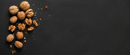 Tasty walnuts on dark background with space for text