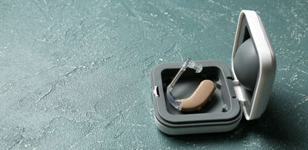 Box with hearing aid on gray background with space for text