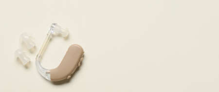 Hearing aid on light background with space for text