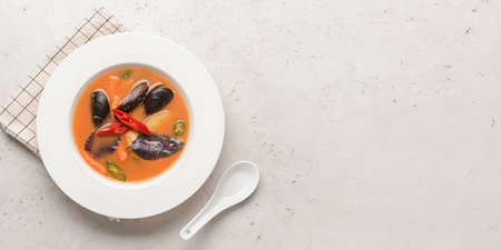 Bowl of spicy Thai soup on light background with space for textの写真素材