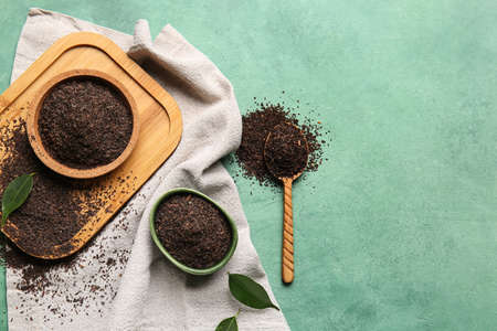 Composition with dry tea leaves on green background, top view