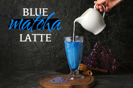 Woman making blue matcha latte on dark backgroundの写真素材