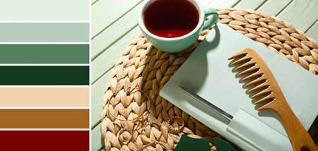 Stylish notebook with pen, hair comb and cup of tea on green wooden background. different color patternsの写真素材