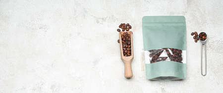 Coffee bag, scoop and spoon on light background with space for textの写真素材
