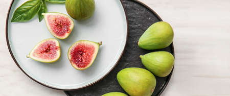 Plates with fresh green figs on light background, top viewの写真素材