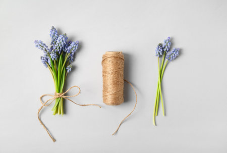 Beautiful Muscari flowers and thread on light backgroundの写真素材