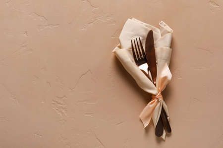 Cutlery with napkin on color background, top viewの写真素材
