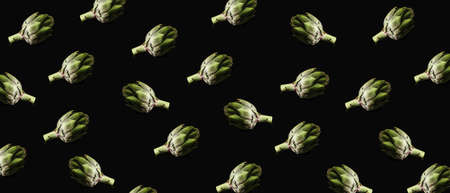 Many raw artichokes on dark backgroundの写真素材