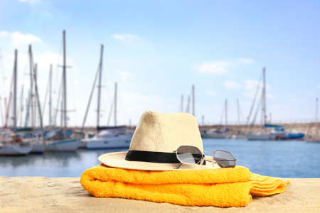 Beach accessories on sand at sea resort with modern yachtsの写真素材
