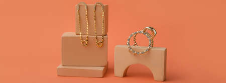 Stylish golden jewelery on orange background
