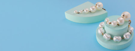 Stylish pearl earrings on light blue background with space for textの写真素材