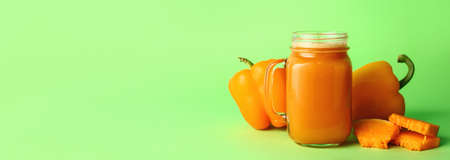 Mason jar of fresh vegetable juice on green background with space for text