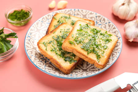 Plate with slices of toasted garlic bread on pink background, closeupの写真素材
