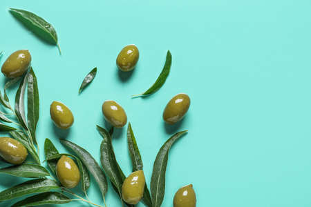green olives and leaves on blue backgroundの写真素材
