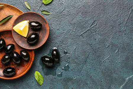 Composition with plates of tasty black olives on dark color backgroundの写真素材