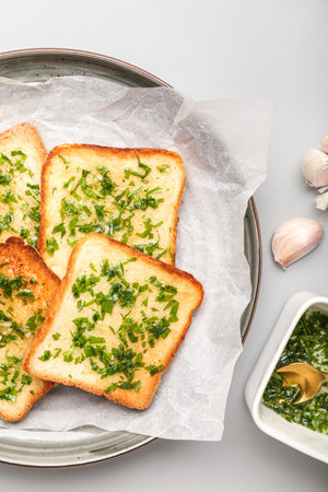 Plate of toasts with garlic and parsley on light background, closeupの写真素材