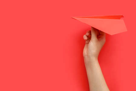Woman with red paper plane on color background