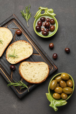 Composition with bowls of olives and fresh bread on dark backgroundの写真素材