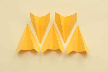 Yellow paper planes on beige background