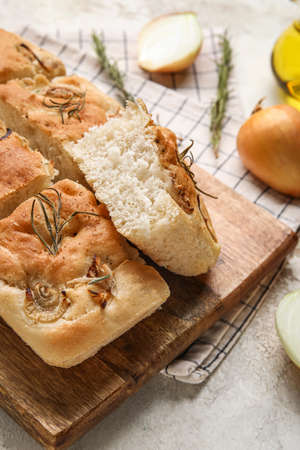 Wooden board with tasty Italian focaccia on table, closeup