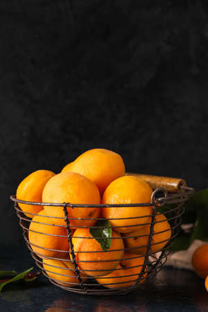Basket with ripe apricots on dark background
