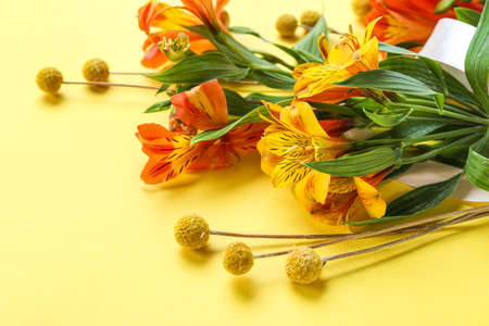 Bouquet of beautiful alstroemeria flowers on yellow background, closeup