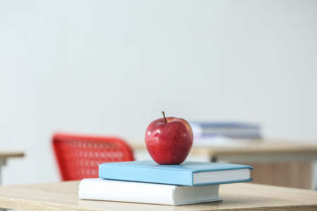 Apple with school books on table in classroom, closeupの写真素材