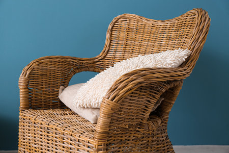 Rattan armchair with pillow near blue wallの写真素材