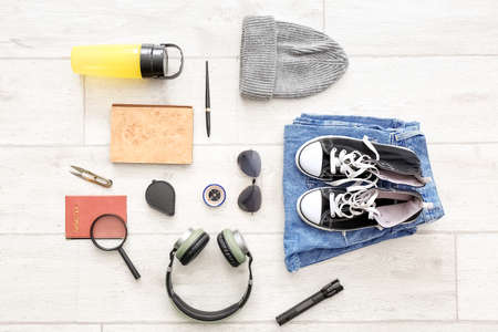 Male accessories for travel with compass on white wooden background