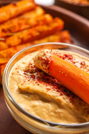 Bowl of tasty sauce and baked carrot, closeupの写真素材