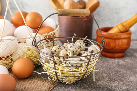 Basket with fresh quail eggs on tableの写真素材