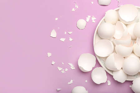 Plate with broken egg shells on lilac backgroundの写真素材