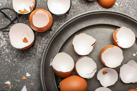 Plate with broken egg shells on grunge background, closeupの写真素材