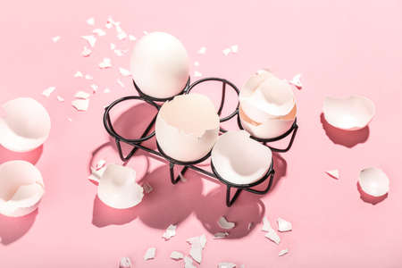 Holder with broken egg shells on color backgroundの写真素材