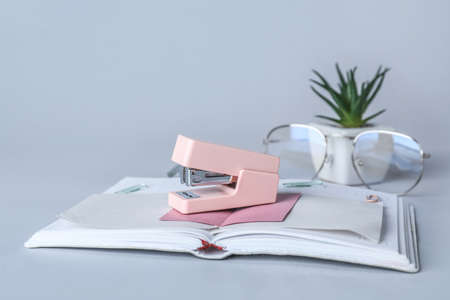 Stapler with sticky notes and notebook on gray background, closeupの写真素材