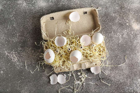 Cardboard holder with broken egg shells on dark backgroundの写真素材