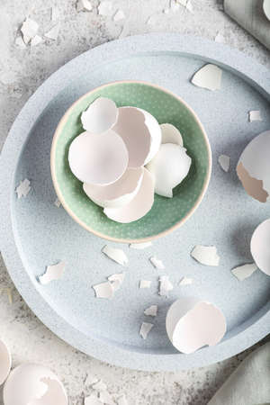 Tray with bowl of broken egg shells on grunge backgroundの写真素材