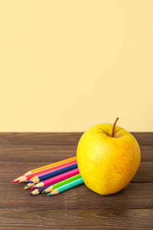 Apple with pencils on table against color backgroundの写真素材