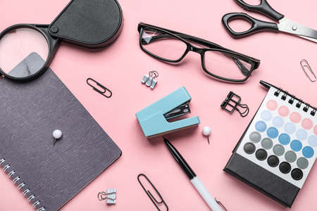 Stapler with different office stationery on pink background