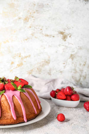Plate with delicious strawberry cake on light background