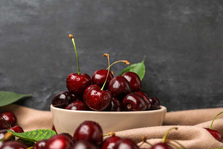 Bowl of tasty cherries on table, closeup